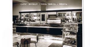 Bar counter with glass displays and seating in a vintage black-and-white setting.